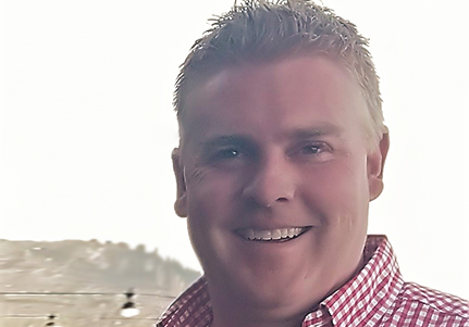 man smiling with red checkered shirt on