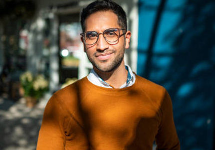 man with brown shirt and glasses