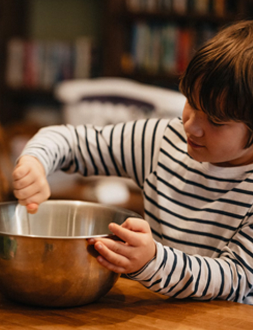 kid mixing in a steel bowl