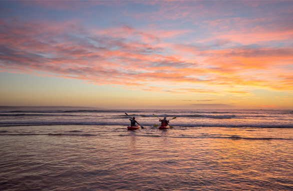 two people kayaking at sunrise