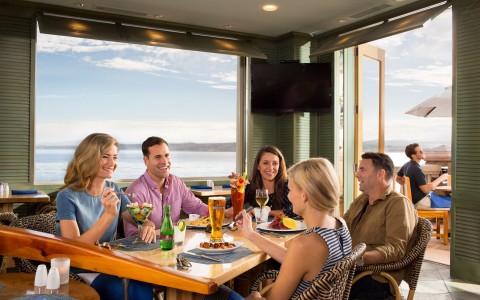 group of friends having a meal with ocean view