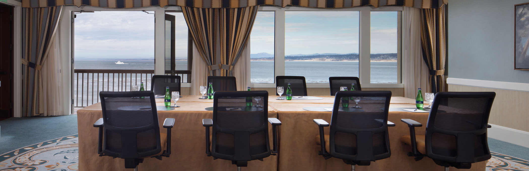 boardroom with open doors to the patio and view of the ocean