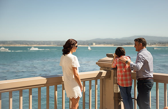 child looking into binoculars at view of pacific ocean