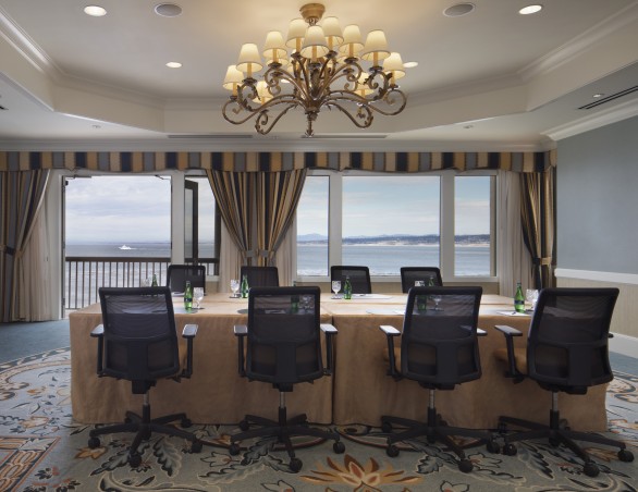 meeting room with a chandelier and brown rectangular table with black chairs