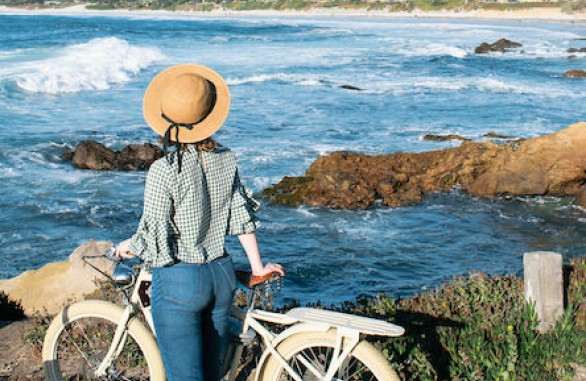 woman with bike near coastline
