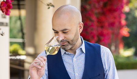 server smelling a glass of white wine