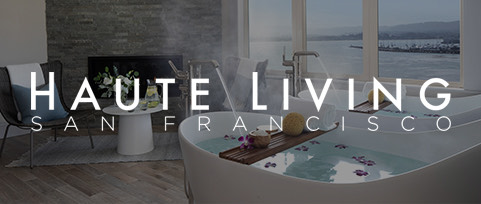 View of a bathtub next to the window with the Haute Living san francisco logo overlapping the image 