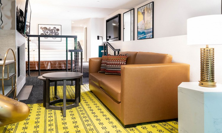 suite with light brown couch and yellow carpet