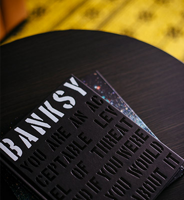 Black table with black book titled Banksy