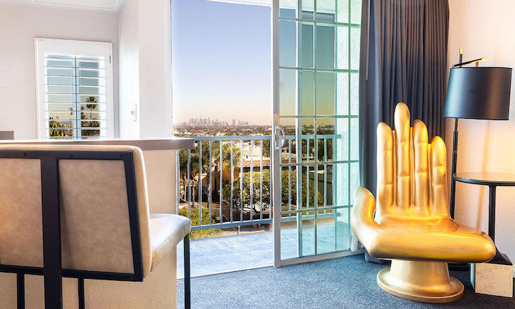 balcony view overlooking city with gold hand shaped chair