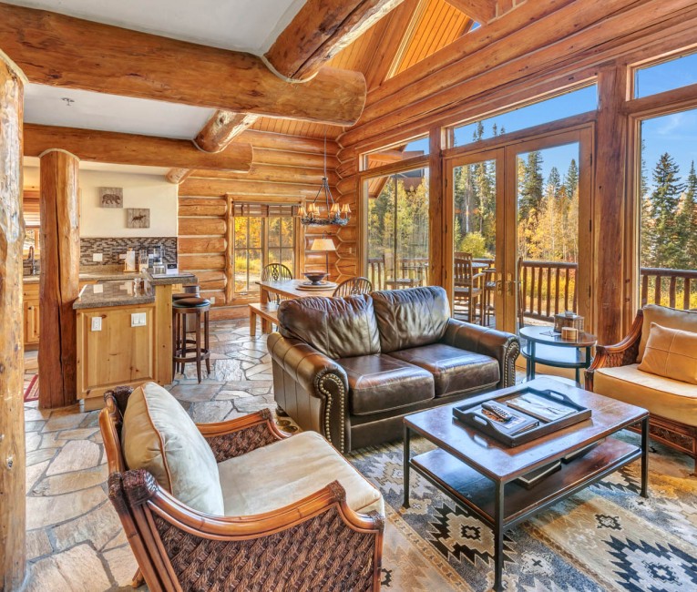 a large cabin with log columns and wooden accents throughout