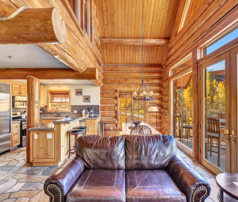 a large cabin with log columns and wooden accents throughout