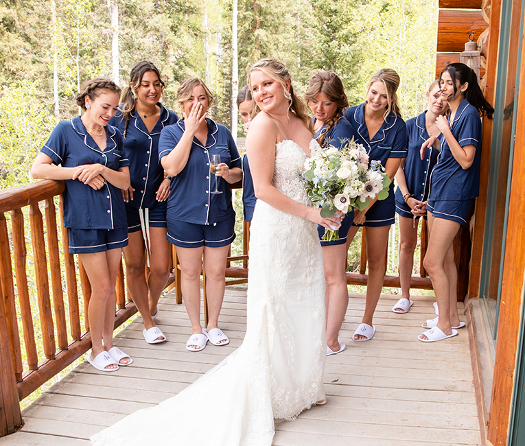 a bride standing on a balcony with her bridesmaids during the day