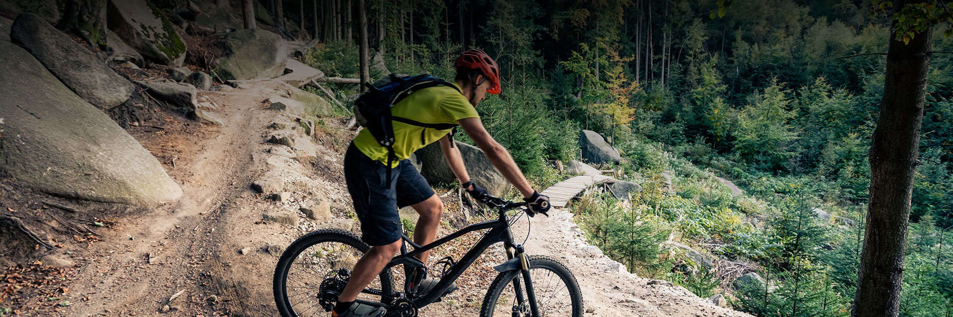 a man riding a mountain bike on a dirt path during the day