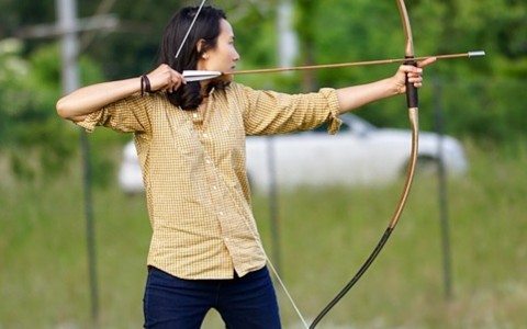 Female archer pulling back bow and arrow