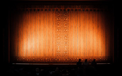 Orange curtain with light shining on it before the show starts