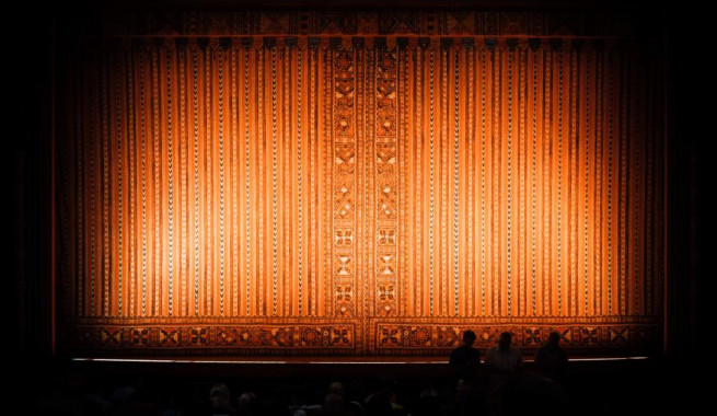 Orange curtain with light shining on it before the show starts