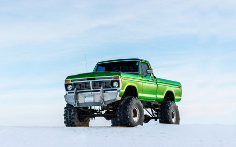green monster truck on a snowy hill