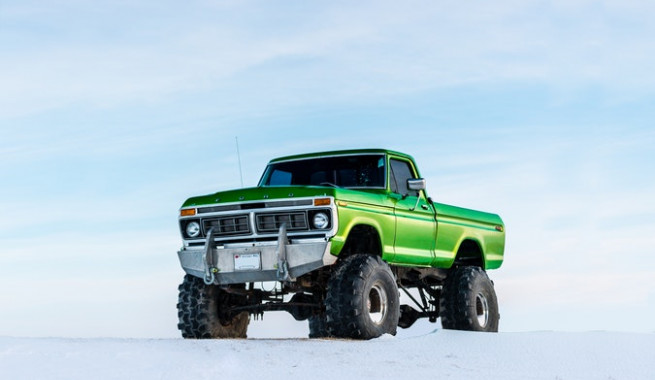 green monster truck on a snowy hill