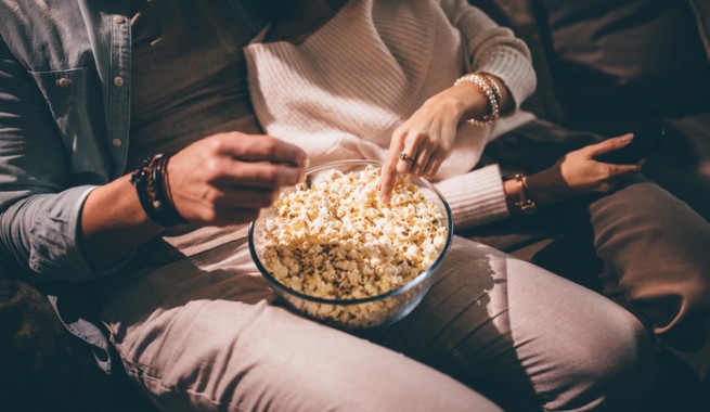 bowl of popcorn on a man's lap
