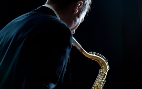 man in suit playing saxophone