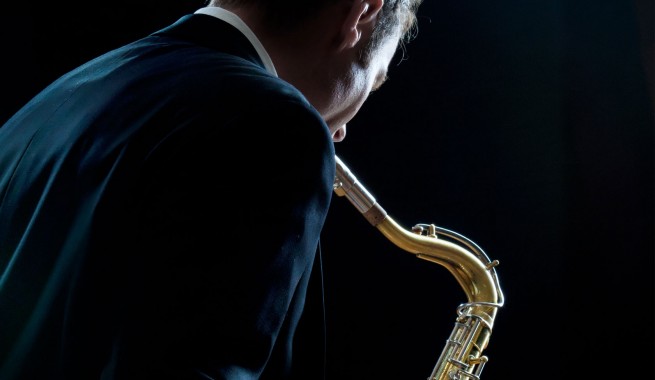 man in suit playing saxophone