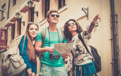 3 groups of friends touring the city, holding a map and pointing