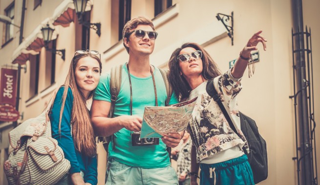 3 groups of friends touring the city, holding a map and pointing