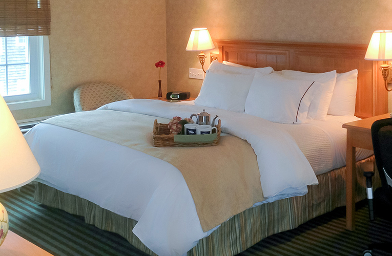 hotel bed with coffee tray perched on covers