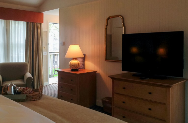 TV, mirror and sofa chair in hotel room