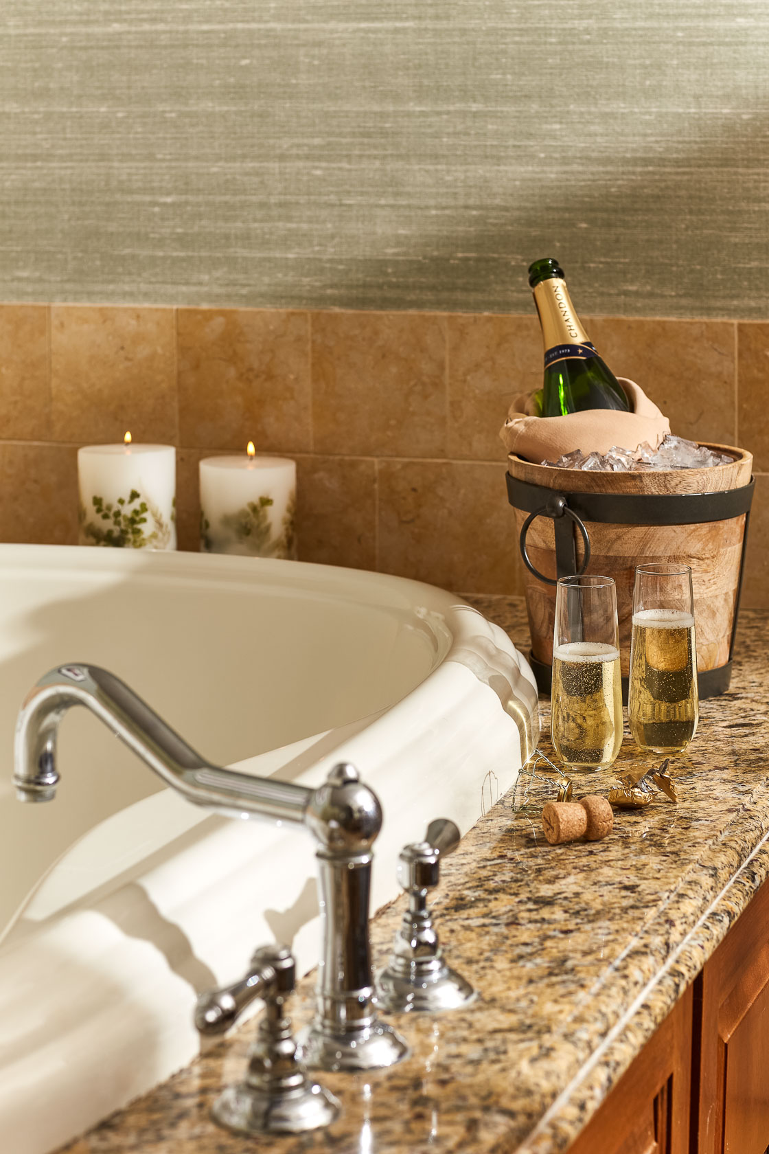 Close up of an elegant bathtub, a basket with a bottle of champaign, two glasses and two candles