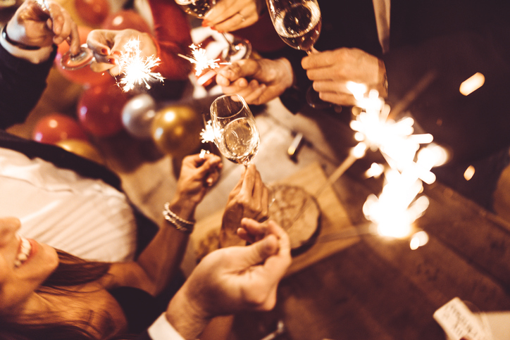 people holding sparklers and champagne flutes