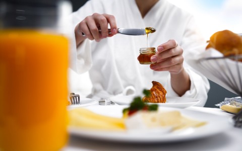 chef pouring honey over a plate 