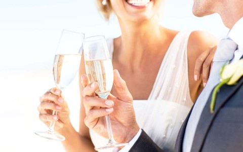 newly wed couple cheering with champagne glasses