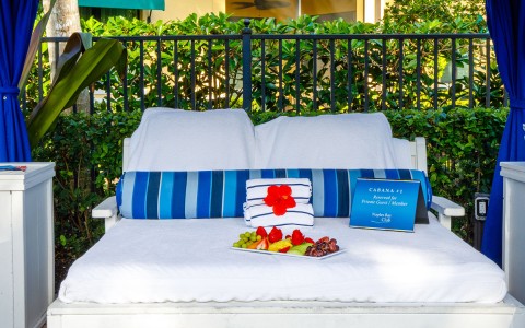 chair with towels, a trail with fruits and a sign for the cabana number