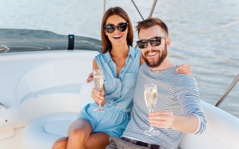 couple holding a champagne glass on a yacht