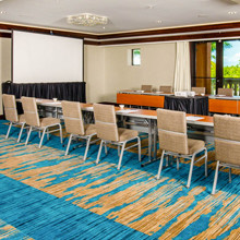 a meeting room with a long table and a projection screen