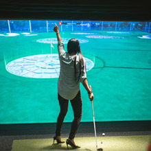 a woman playing an electronic golf game