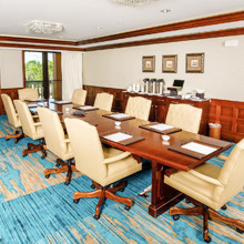a meeting room with a long wooden table and beige chairs