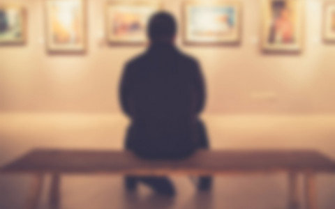 man on bench in art gallery