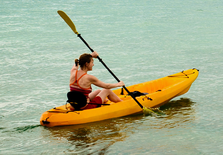 a woman on a yellow kayak in the water