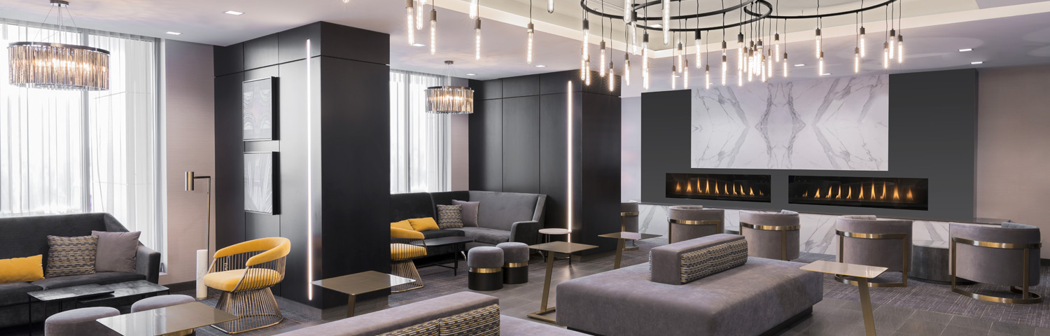 Hotel room with grey walls, modern ligh fixture and fireplace