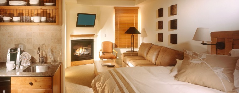 photo of suite with a fireplace, couch, and kitchen 
