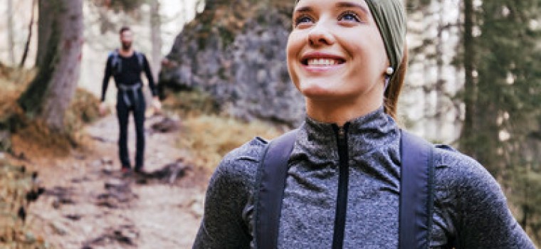 a woman and a man hiking in a forest