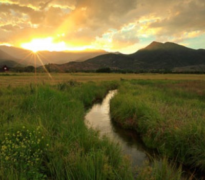 rural utah with the sun shining behind the mountains