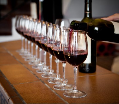 man pouring wine into glasses