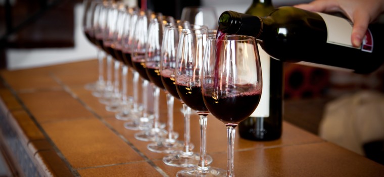 man pouring wine into glasses