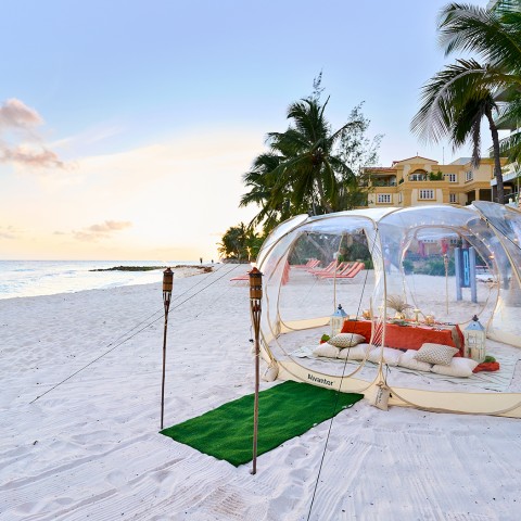 bubble in the beach with lanterns and green carpet leading in