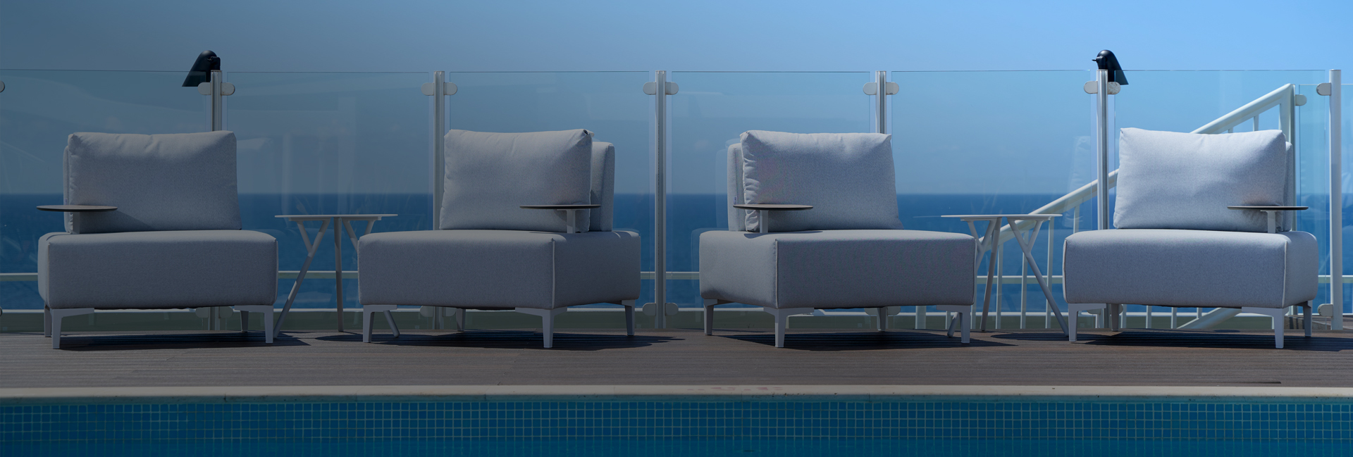 4 white chairs next to ledge of pool