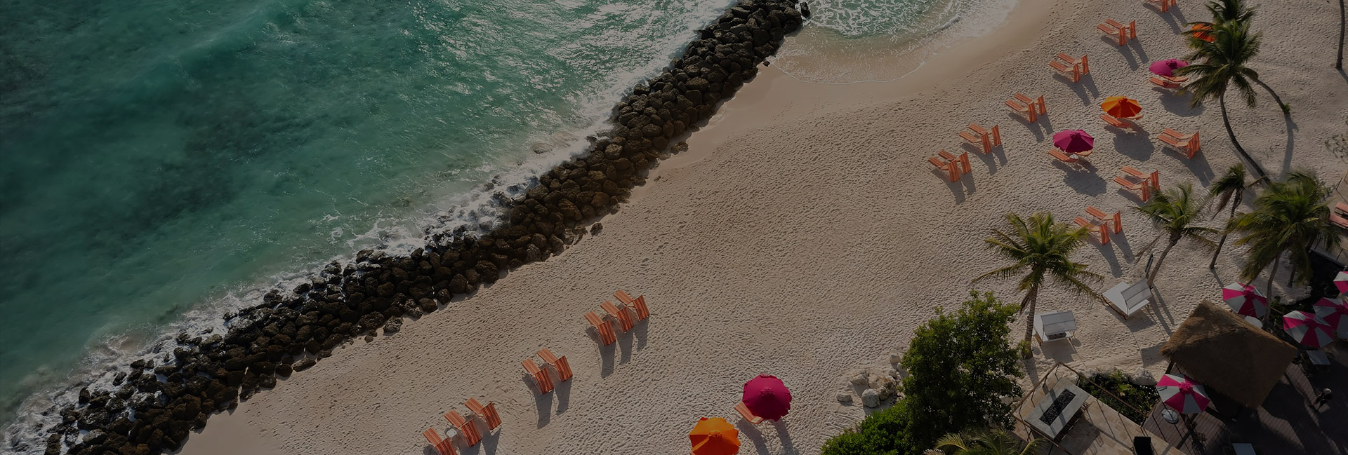 aerial shot of ocean line and beach with beach chairs